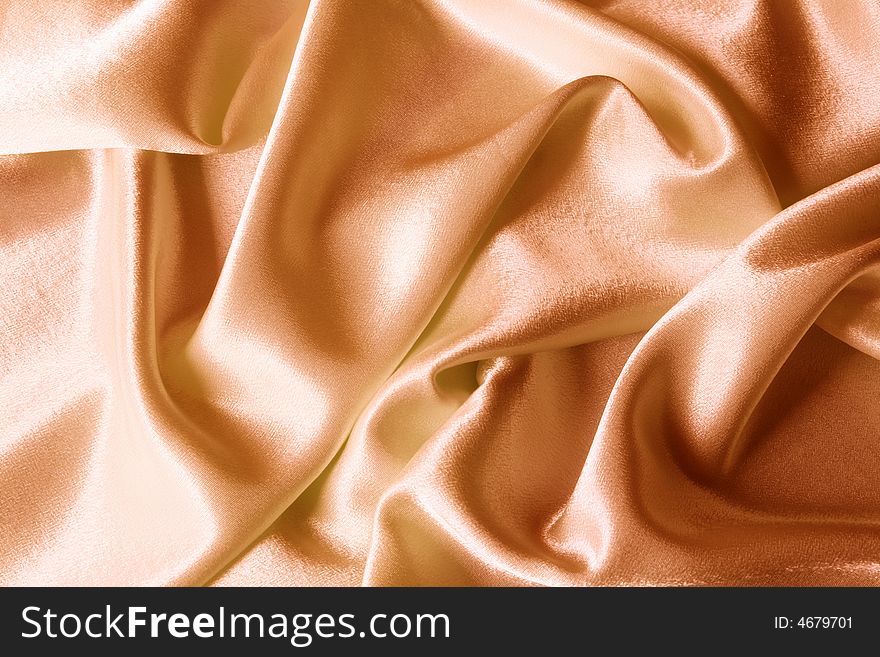 An image of folds of golden shine fabric. An image of folds of golden shine fabric