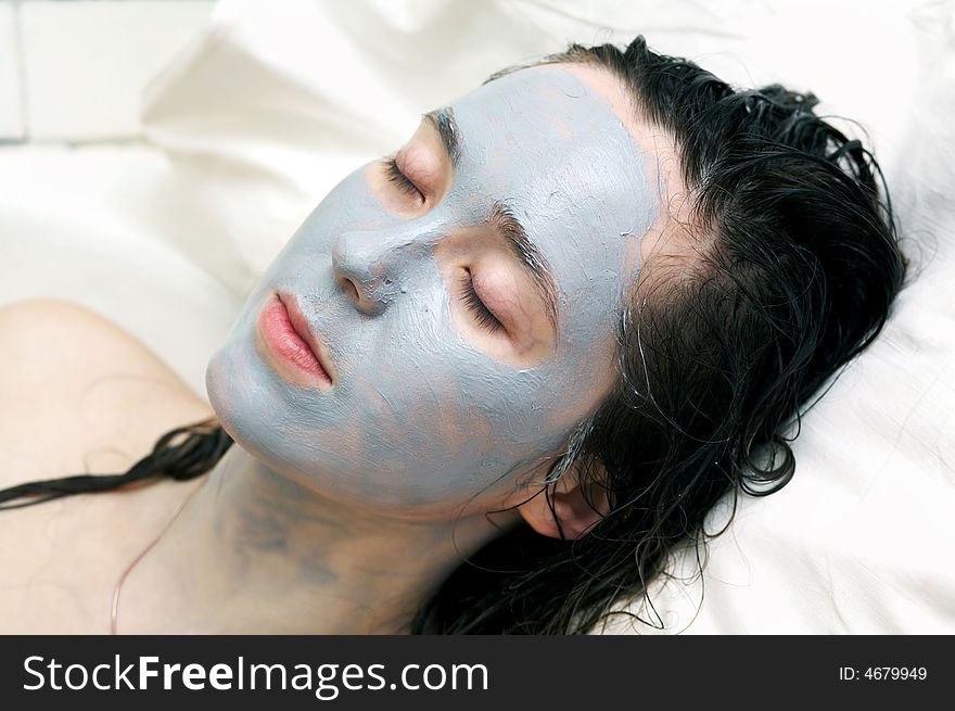 A nice woman putting a mud mask on her face. A nice woman putting a mud mask on her face