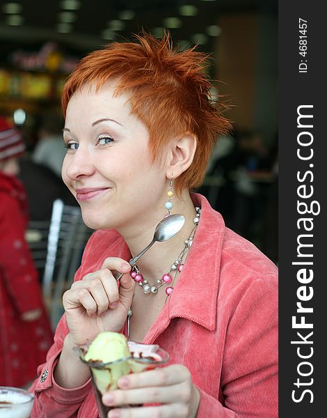 Woman eating ice cream in cafe and smiling happy