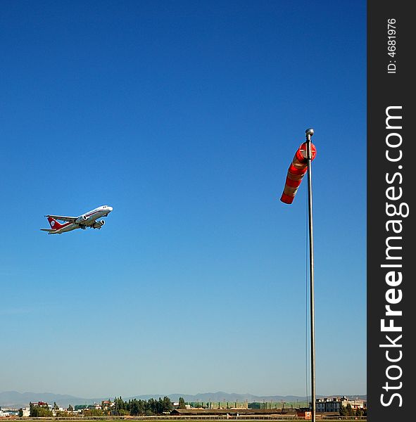 The plane was taking off at the airport and the wind indicator. The plane was taking off at the airport and the wind indicator