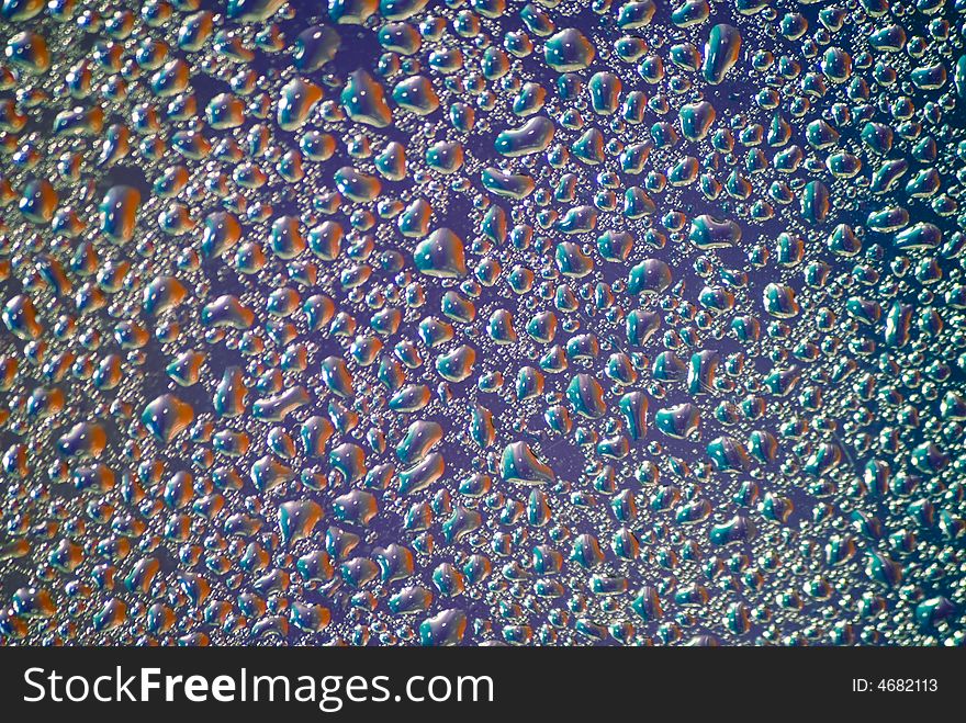 Water drops on the violet background. Blur on the edges of the frame ï¿½ lens feature.