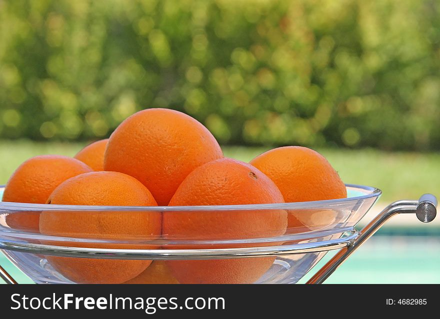 Florida oranges in a modern bowl over looking a bright backyard