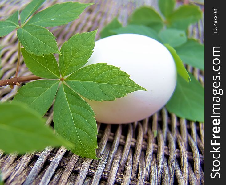 Unpainted white egg on wicker background. Unpainted white egg on wicker background