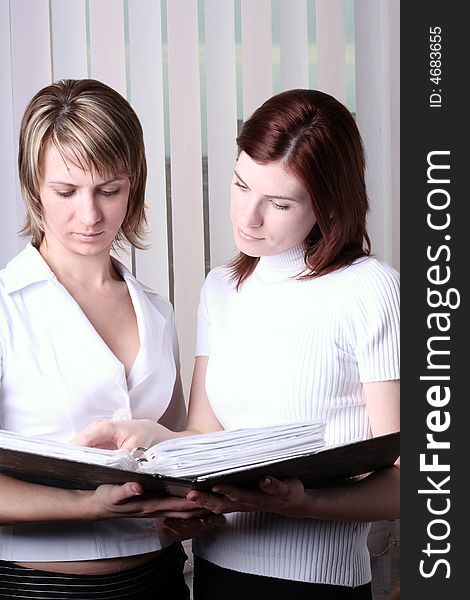Two girls at office cost and consider documents