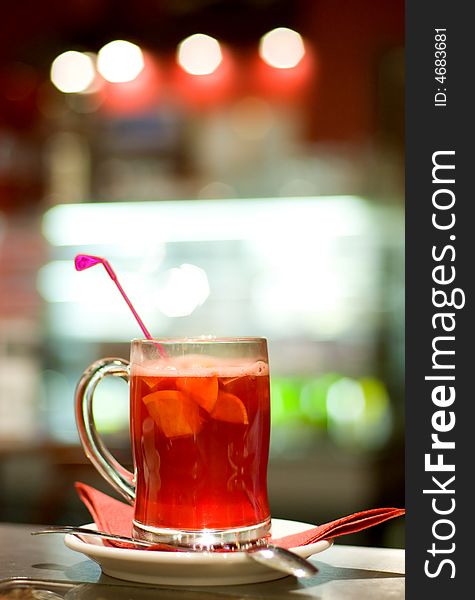Cup of fruit tea on abstract blurred background (shallow DoF)