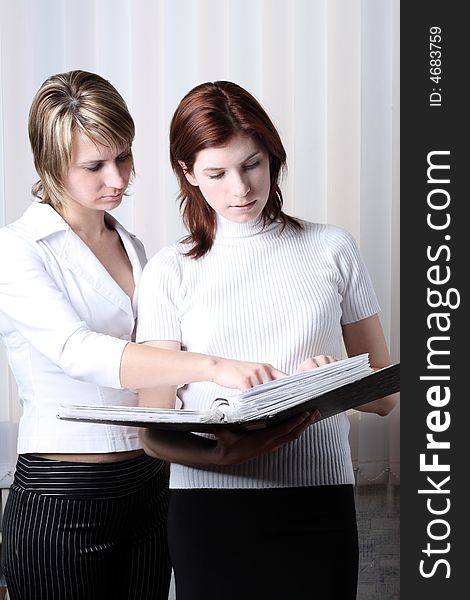 Two girls at office cost and consider documents