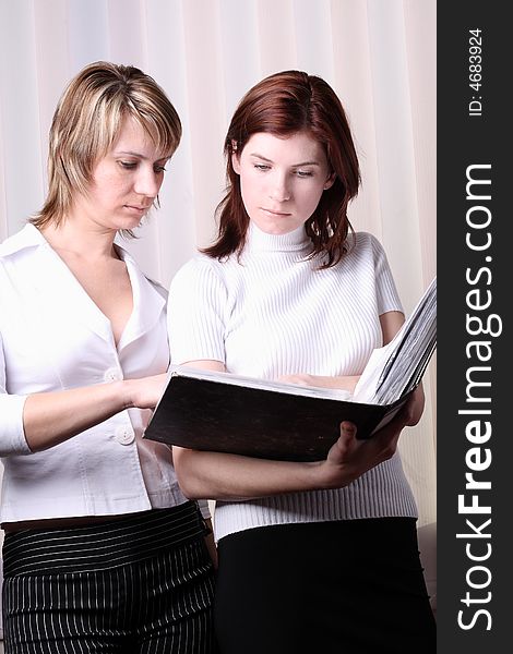 Two girls at office cost and consider documents