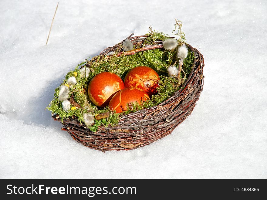 White snow and Easter Eggs in the basket. White snow and Easter Eggs in the basket