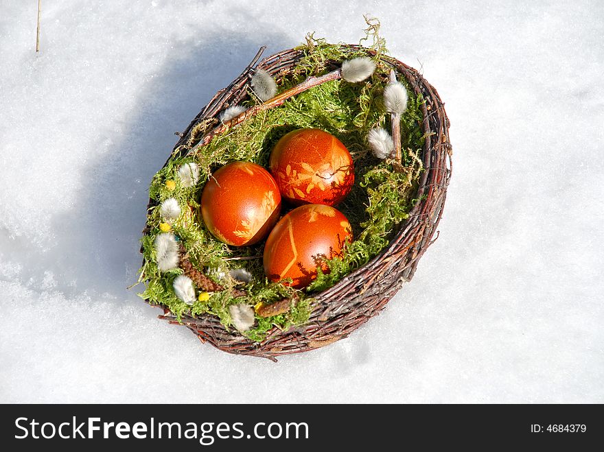 White snow and Easter Eggs in the basket. White snow and Easter Eggs in the basket