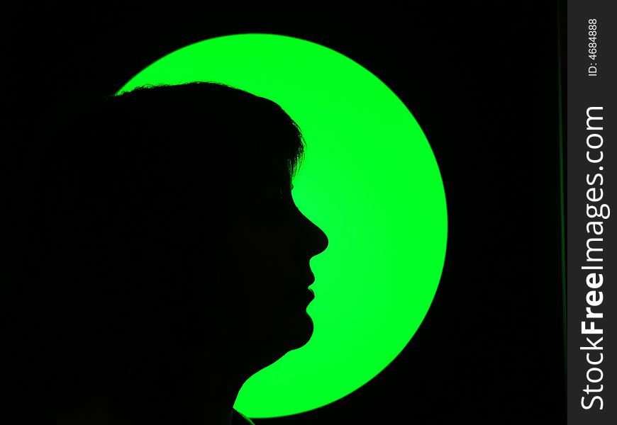Silhouette of woman in green light and black background