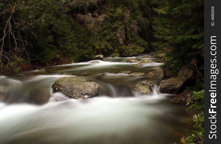 The water of a torrent flow between mountain rocks. The water of a torrent flow between mountain rocks