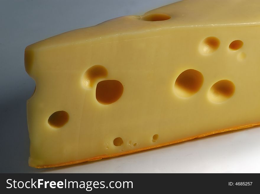 Fresh and tasty slice of cheese, close-up, dark background