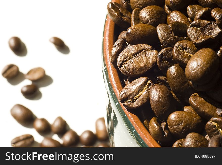 Coffee beans in mug and on white background. Coffee beans in mug and on white background