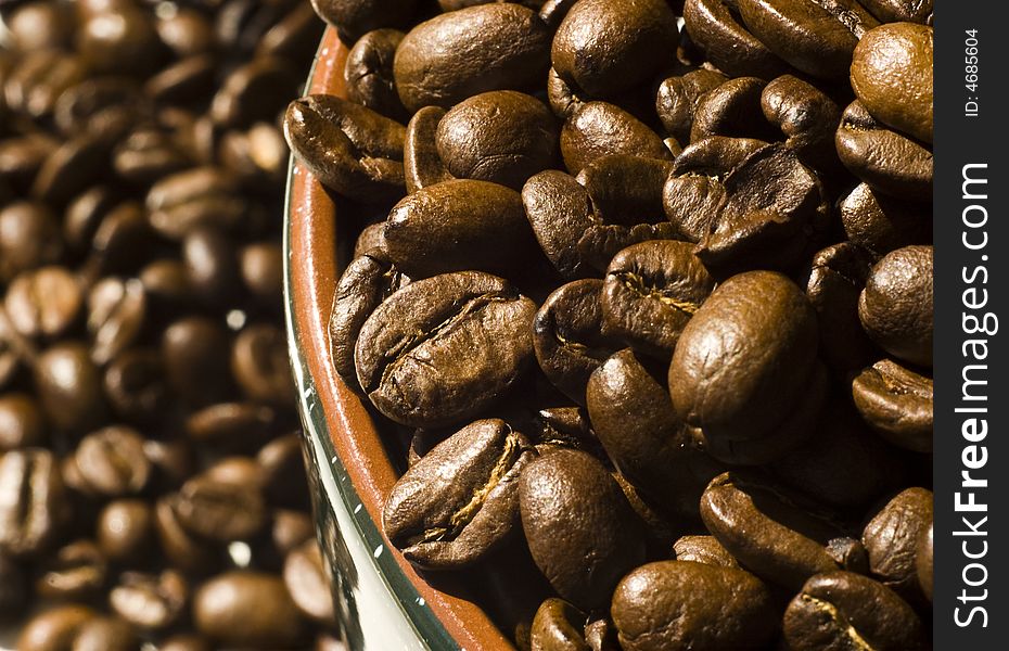 Coffee beans in mug and in background. Coffee beans in mug and in background