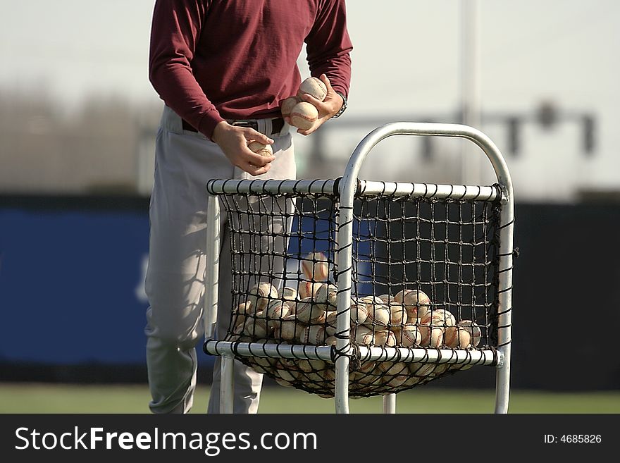 Baseball player taking baseballs from stock. Baseball player taking baseballs from stock