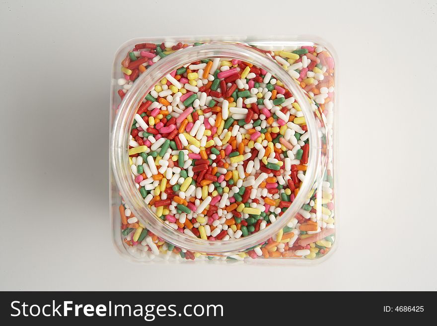 Overhead image of an opened plastic sprinkles jar. Overhead image of an opened plastic sprinkles jar.