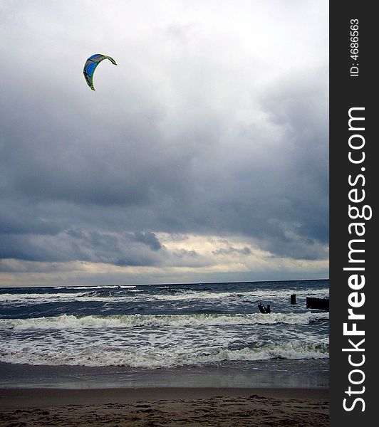 Kiteboarder preparing his kite in a sea.