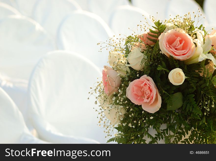 Empty white covered chairs and a bouquet of flowers. Empty white covered chairs and a bouquet of flowers
