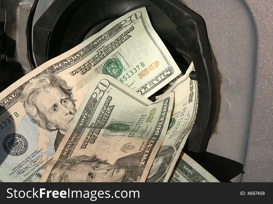 Twenty dollar bills pouring into a gas tank. Twenty dollar bills pouring into a gas tank.