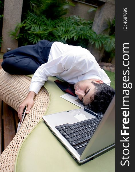Man in business attire asleep in front of his laptop. Man in business attire asleep in front of his laptop