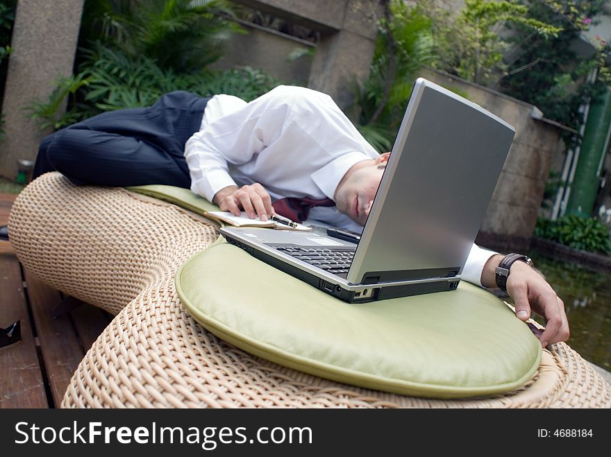 Male in business attire sprawled out in front of his laptop. Male in business attire sprawled out in front of his laptop