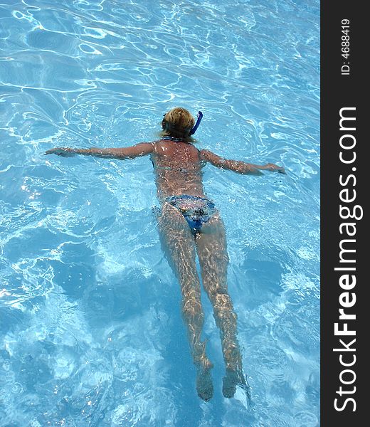 Young woman snorkeling in a pool exercises before underwater experience