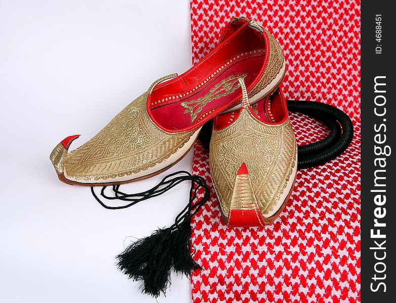 Arabic slippers on white and red background.