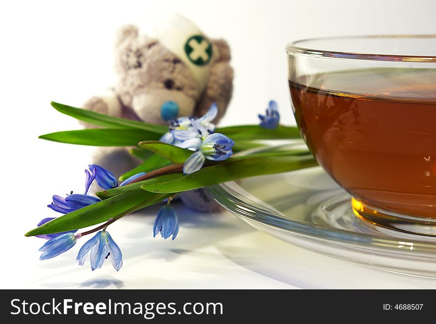 Snowdrops, toy a bear and a cup of tea. Snowdrops, toy a bear and a cup of tea