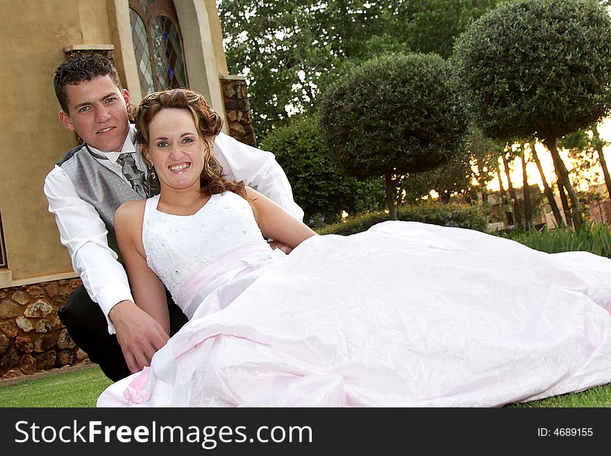 A groom and bride together in front of building. A groom and bride together in front of building
