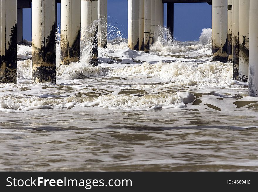 White waves breaking on concrete pillars