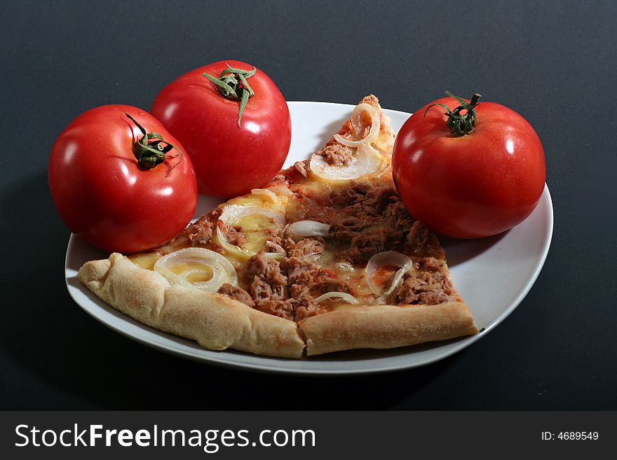 Pizza with tomatoes on a black background.