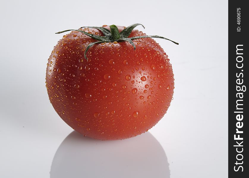 Shot of a tomato on white background with water drops. Shot of a tomato on white background with water drops