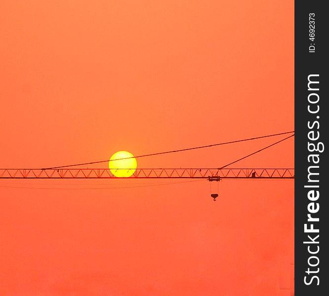 The crane of a construction site in the twilight . The crane of a construction site in the twilight .