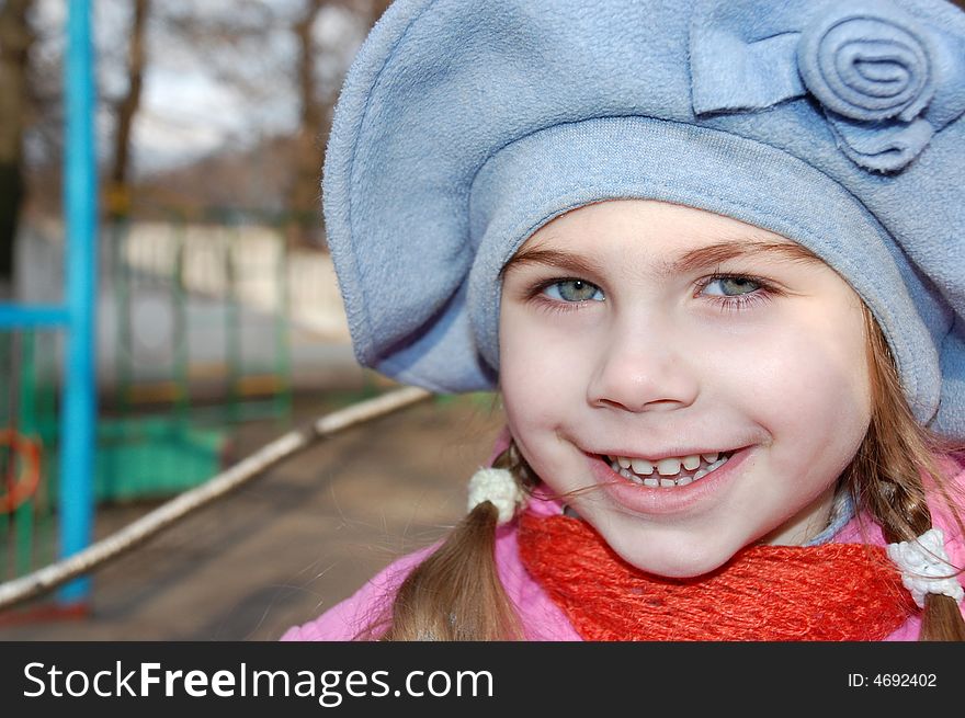 Pretty little girl outdoors wearing a big blue hat. Pretty little girl outdoors wearing a big blue hat