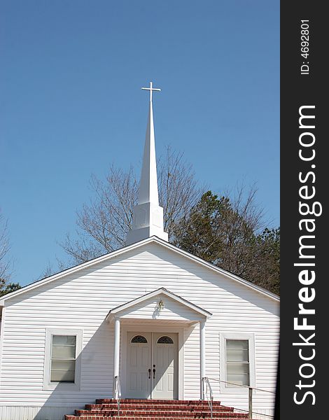 The front of a country church with its steeple. The front of a country church with its steeple
