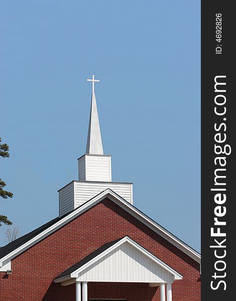 A church steeple rises into a clear, blue sky. A church steeple rises into a clear, blue sky