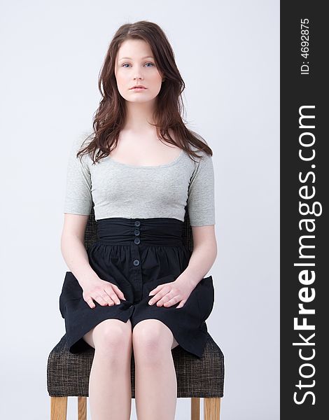 Portrait of young beautiful woman sitting on the chair