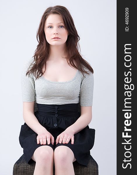 Portrait of young beautiful woman sitting on the chair