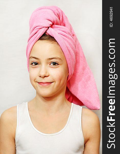 Beautiful smiling young lady with a pink towel on her head. Beautiful smiling young lady with a pink towel on her head