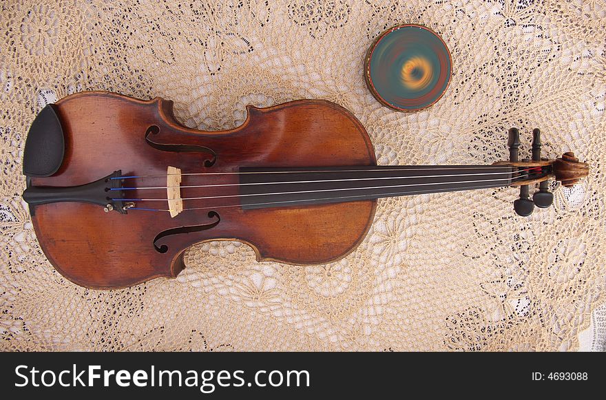 Old violin lying on a table with equipment