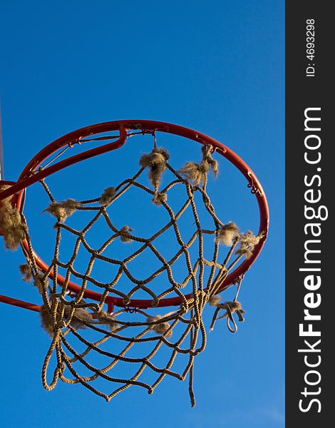 Single basketball hoop with net under the blue sky