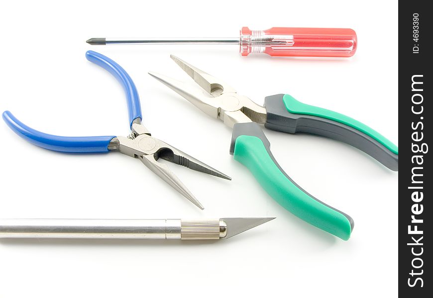 Set of nippers and screwdrivers with plastic multi-coloured handles on a white background. Set of nippers and screwdrivers with plastic multi-coloured handles on a white background