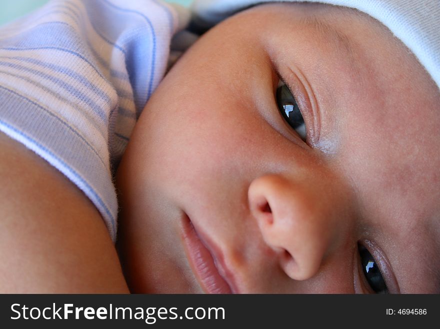 Week old baby boy on a blue blanket early in the morning. Week old baby boy on a blue blanket early in the morning