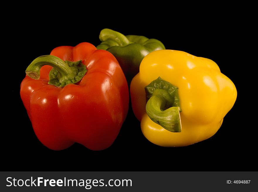 Red green and yellow Bell Peppers on a black background. Red green and yellow Bell Peppers on a black background