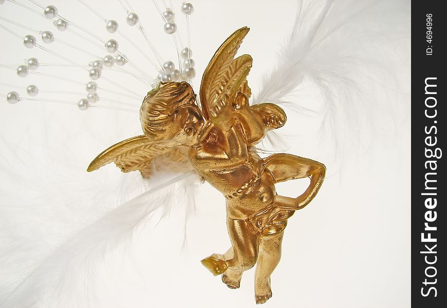 Golden Angel plays his flute, placed on white feather and pearls. Golden Angel plays his flute, placed on white feather and pearls