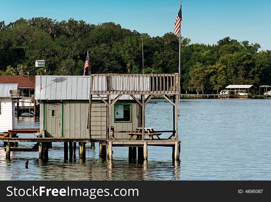 A dock house with picnic table and American flag