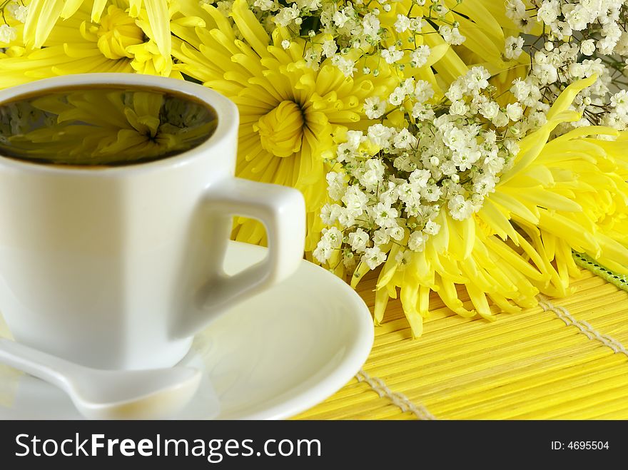 Morning cup of coffee with flowers on the table. Shallow DOF