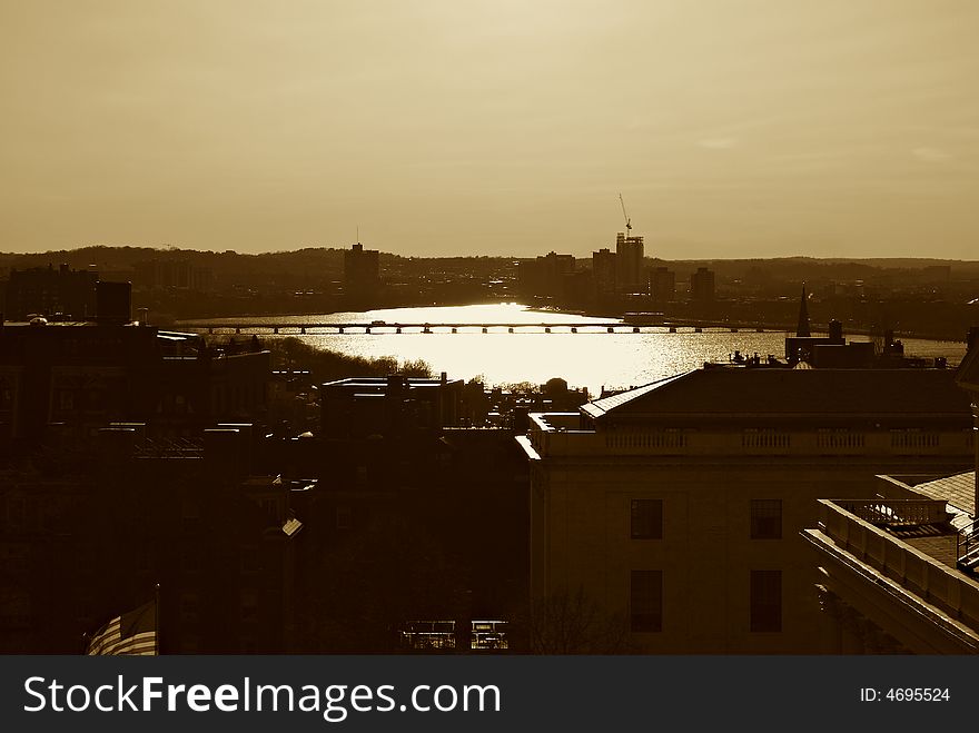 Sepia toned image of the sun setting over the river charles in boston massachusetts. Sepia toned image of the sun setting over the river charles in boston massachusetts