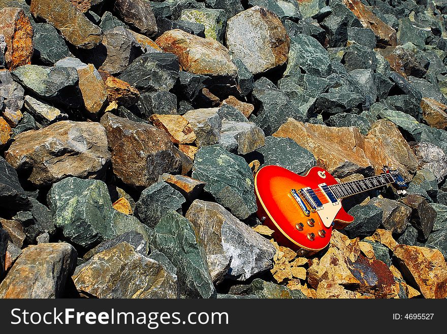 Vintage Electric Sunburst Style Guitar on the Rocks. Vintage Electric Sunburst Style Guitar on the Rocks