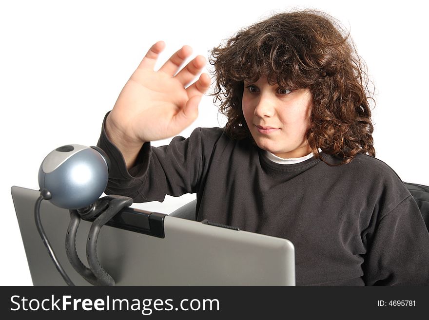 Boy using laptop, waving hand of a webcam